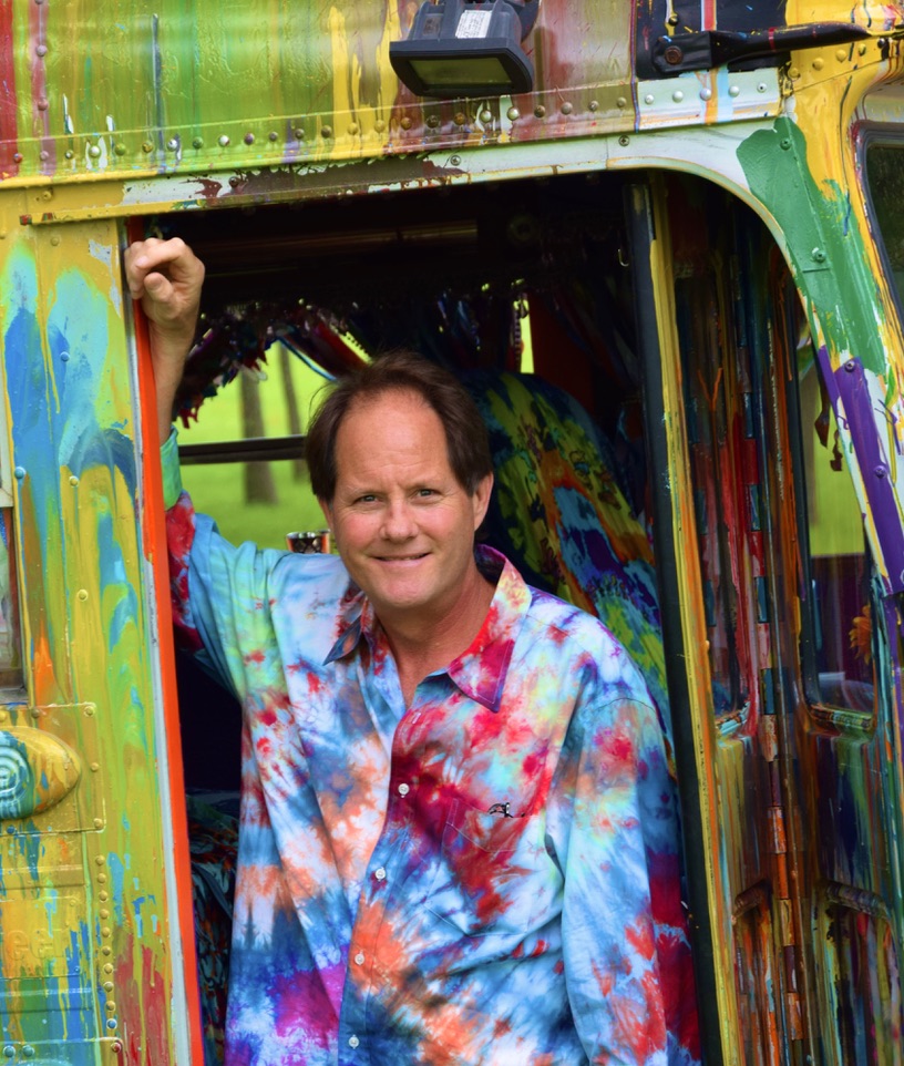 David McQuaid standing in the doorway of a colorful painted bus
